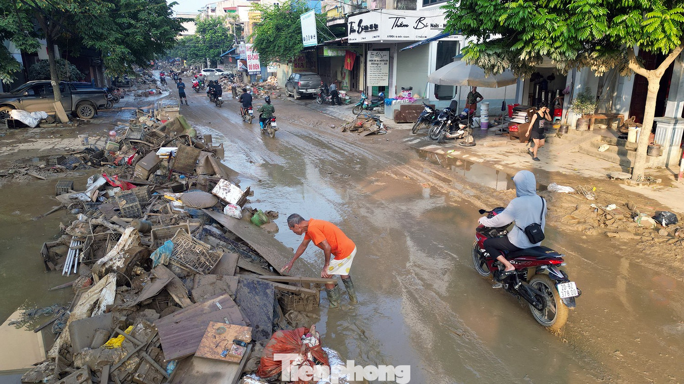 Sau nhiều ngày chìm trong biển nước, khu phố chợ Túc Duyên hiện ra với lớp bùn đất dày, rác thải ngổn ngang. Trong làn sương sớm, người dân lặng lẽ bắt tay dọn dẹp, khôi phục sạp hàng, cùng nhau dựng lại cuộc sống từ những gì còn sót lại sau lũ.