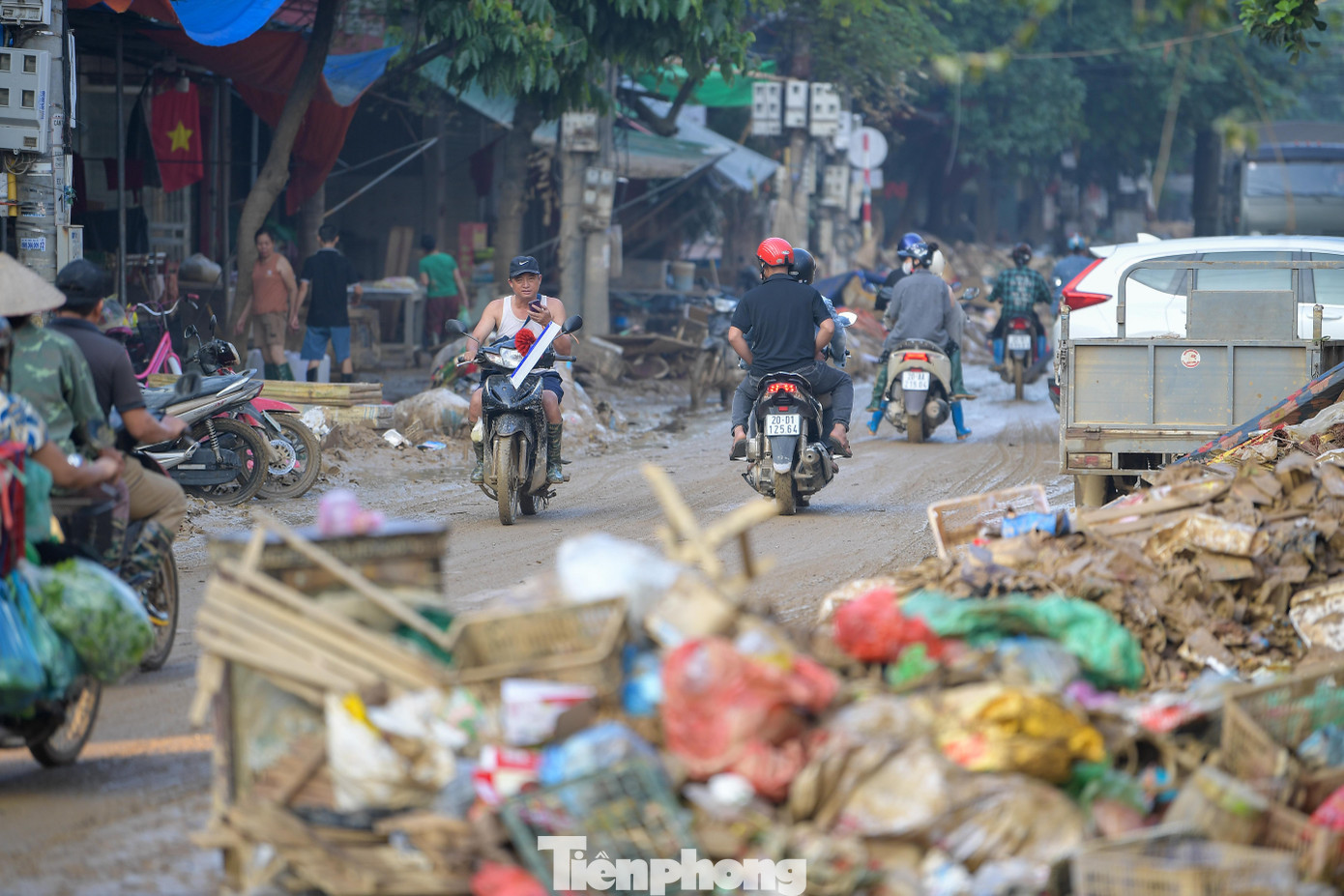 Tiếng xẻng, tiếng chổi, tiếng xe cuốn ép rít lên giữa khung cảnh ngổn ngang. Họ chia nhau làm từng khu, vừa dọn vừa hô hào thêm người cùng tham gia.