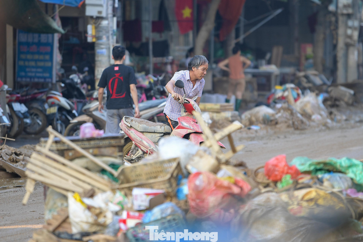 Các con ngõ dẫn quanh chợ đều ngập rác. Thùng xốp, quần áo, tủ nhựa bị cuốn ra tận cổng. Trên tường, vệt nước bẩn vẫn hằn cao quá thắt lưng.