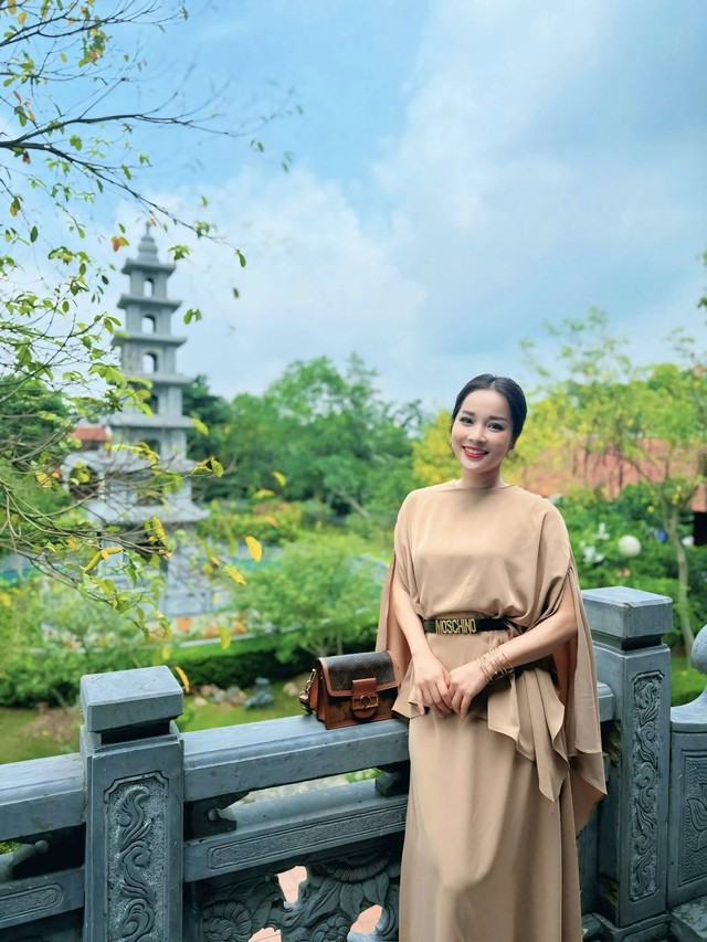 BTV Minh Hương lúc khác lại chững chạc trong set váy dài màu be dịu nhẹ, điểm nhấn là thắt lưng Moschio sang trọng và high fashion.