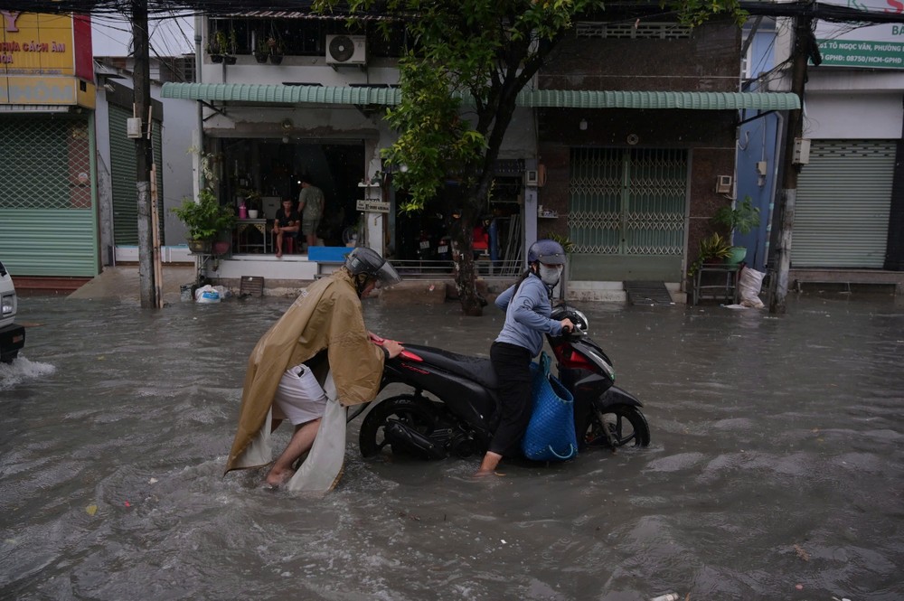 Mưa lớn, người dân TP.HCM vất vả vượt đường ngập - 9
