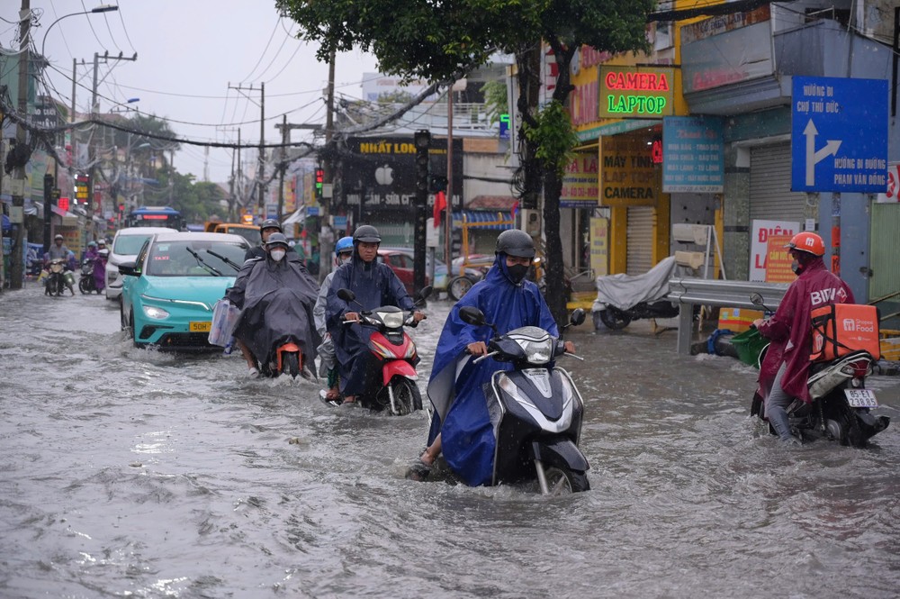Đường Tô Ngọc Vân ngập hơn nửa bánh xe sau mưa, khiến nhiều người điều khiển xe máy, ô tô phải quay đầu, lựa chọn lộ trình khác để tránh tình trạng chết máy giữa dòng nước. Ảnh: PHẠM HẢI