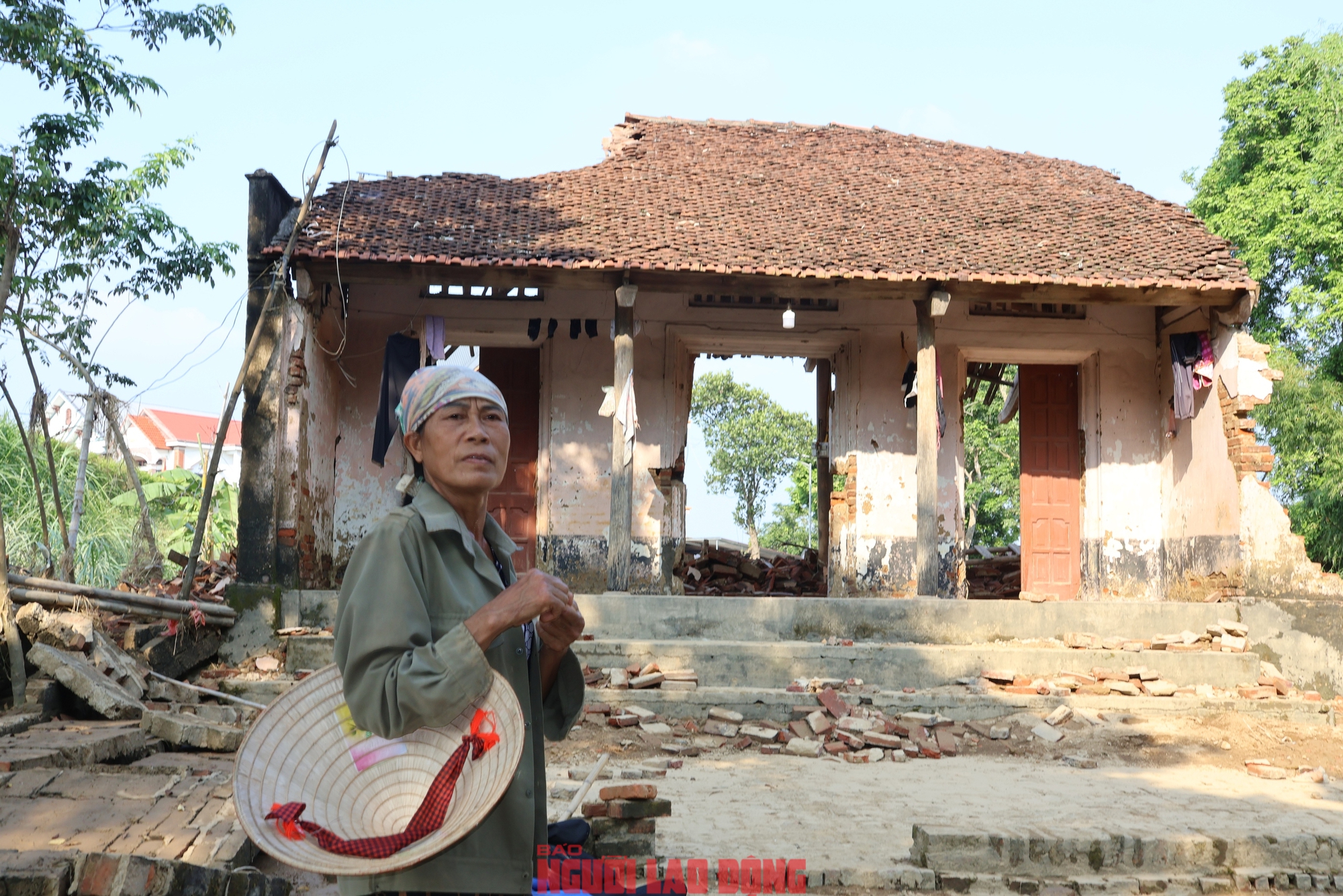 Bà Trương Thị Hoạt ngẩn ngơ bên căn nhà của mình đã bị lũ cuốn hết tài sản. Ảnh: Văn Duẩn