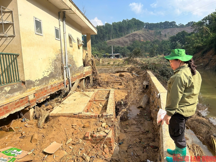 Cô Dương Thị Yến buồn bã nhìn dãy phòng học bị lũ cuốn toàn bộ phần nền, lộ rõ móng nhà