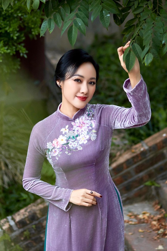 Khi thì cô chọn áo dài gam màu tím dịu dàng và nữ tính.