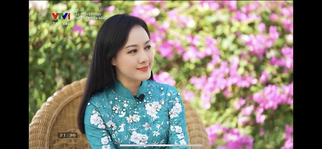 BTV lúc khác thì chọn áo dài điểm xuyết hoa trắng mix tông áo màu xanh dịu dàng.