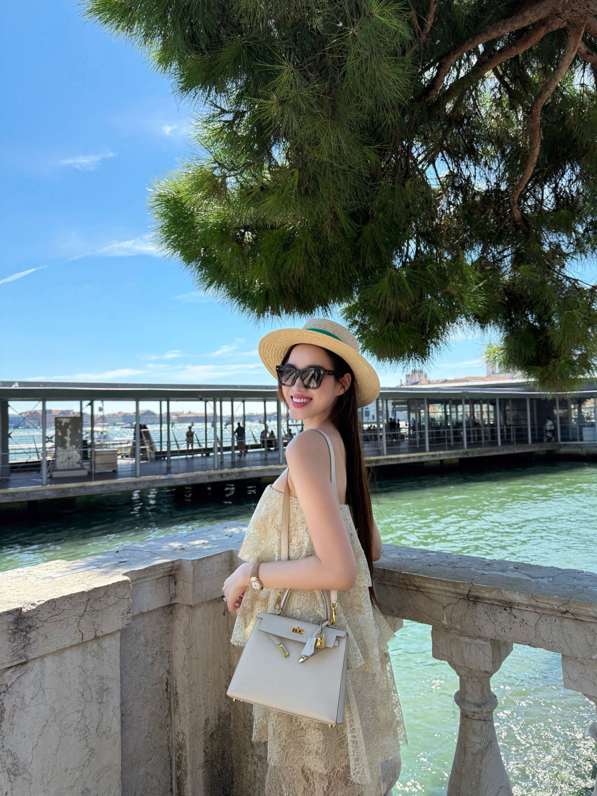 Đỗ Thị Hà tô điểm phong cách bằng kính râm bản lớn Louis Vuitton, đồng hồ Patek Philippe và mũ cói đậm tinh thần mùa hè.
