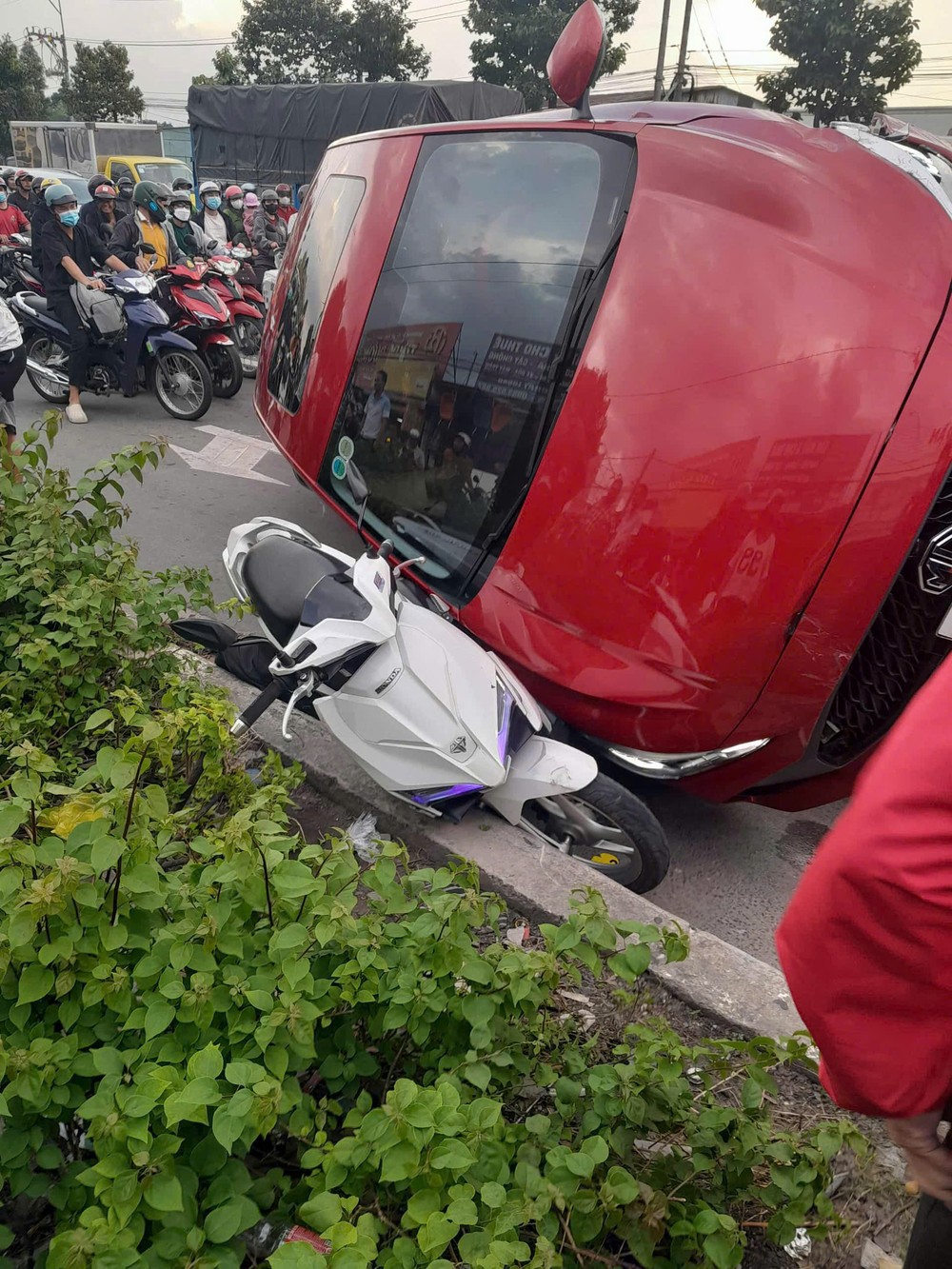 Nhiều xe máy nằm bị xe ô tô con húc văng nằm trên đường.