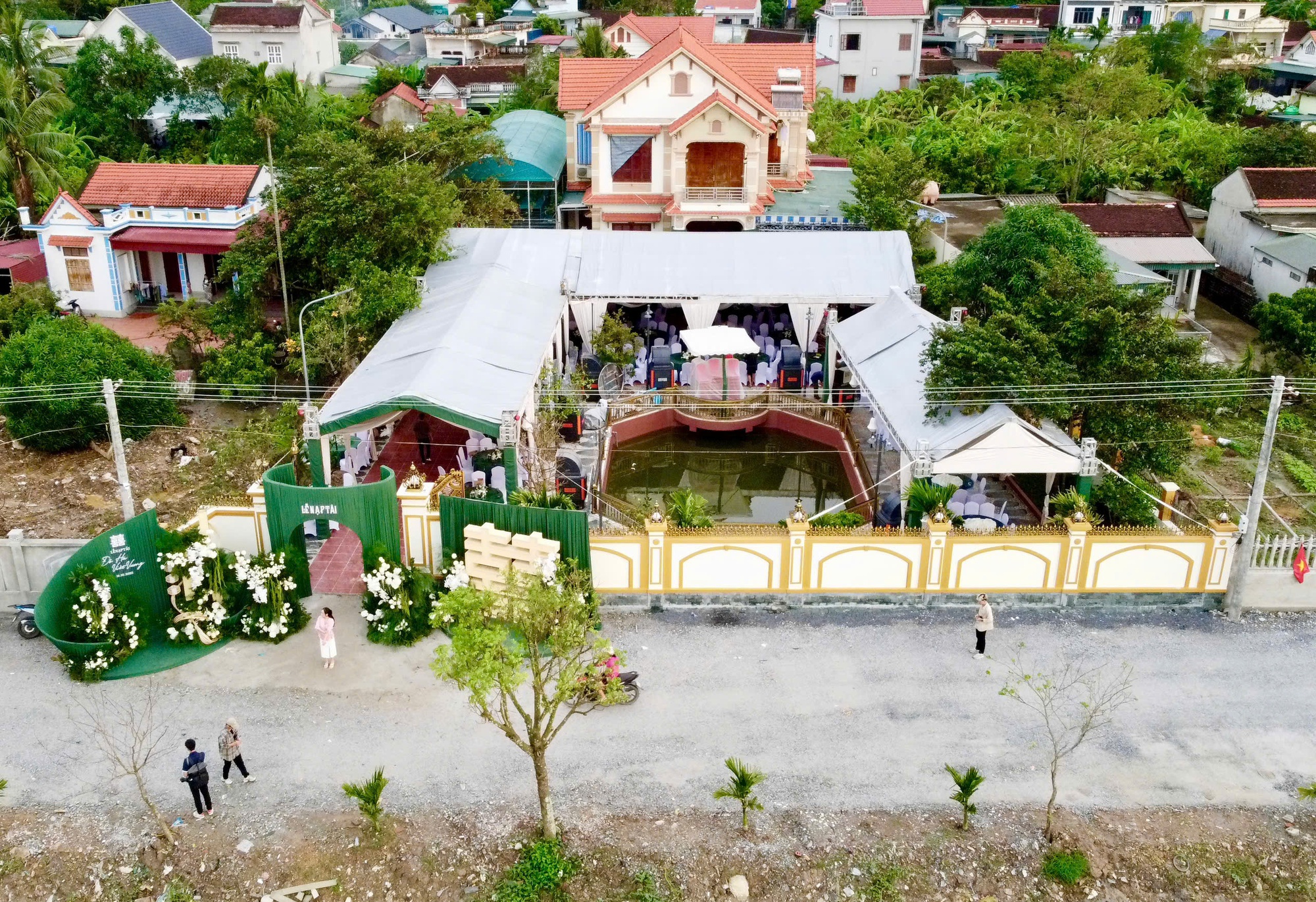 Khu vực sân trong khuôn viên của gia đình Hoa hậu Đỗ Thị Hà được dựng rạp, cổng chào lấy tông màu xanh.