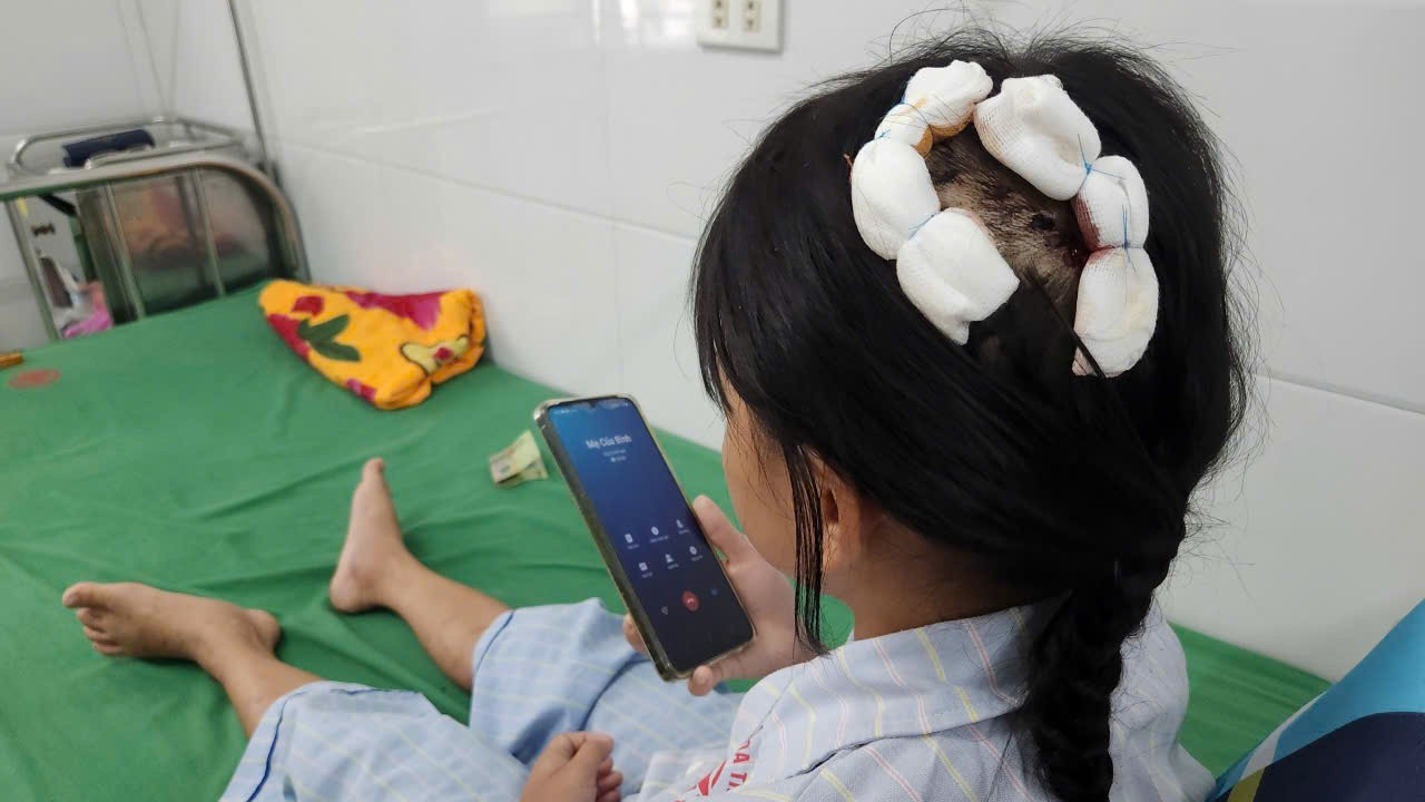 Hiện cháu L. đang được điều trị tại bệnh viện, trên đầu bị thương do cha dượng dùng búa đinh đánh.