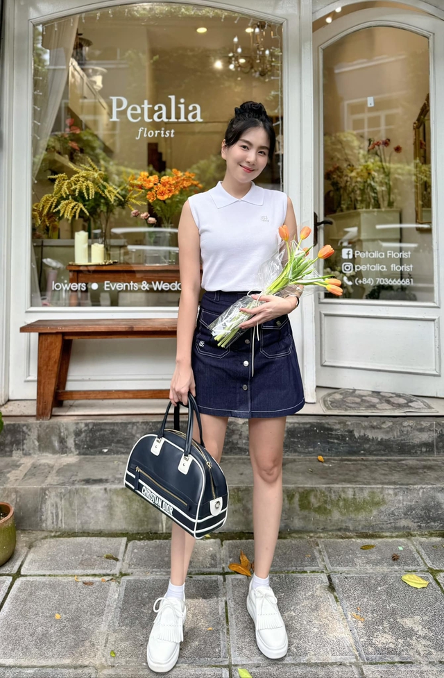 Lúc khác, nữ BTV lại diện áo sát nách cùng chân váy khoe chân cùng giày trắng năng động, trẻ trung.