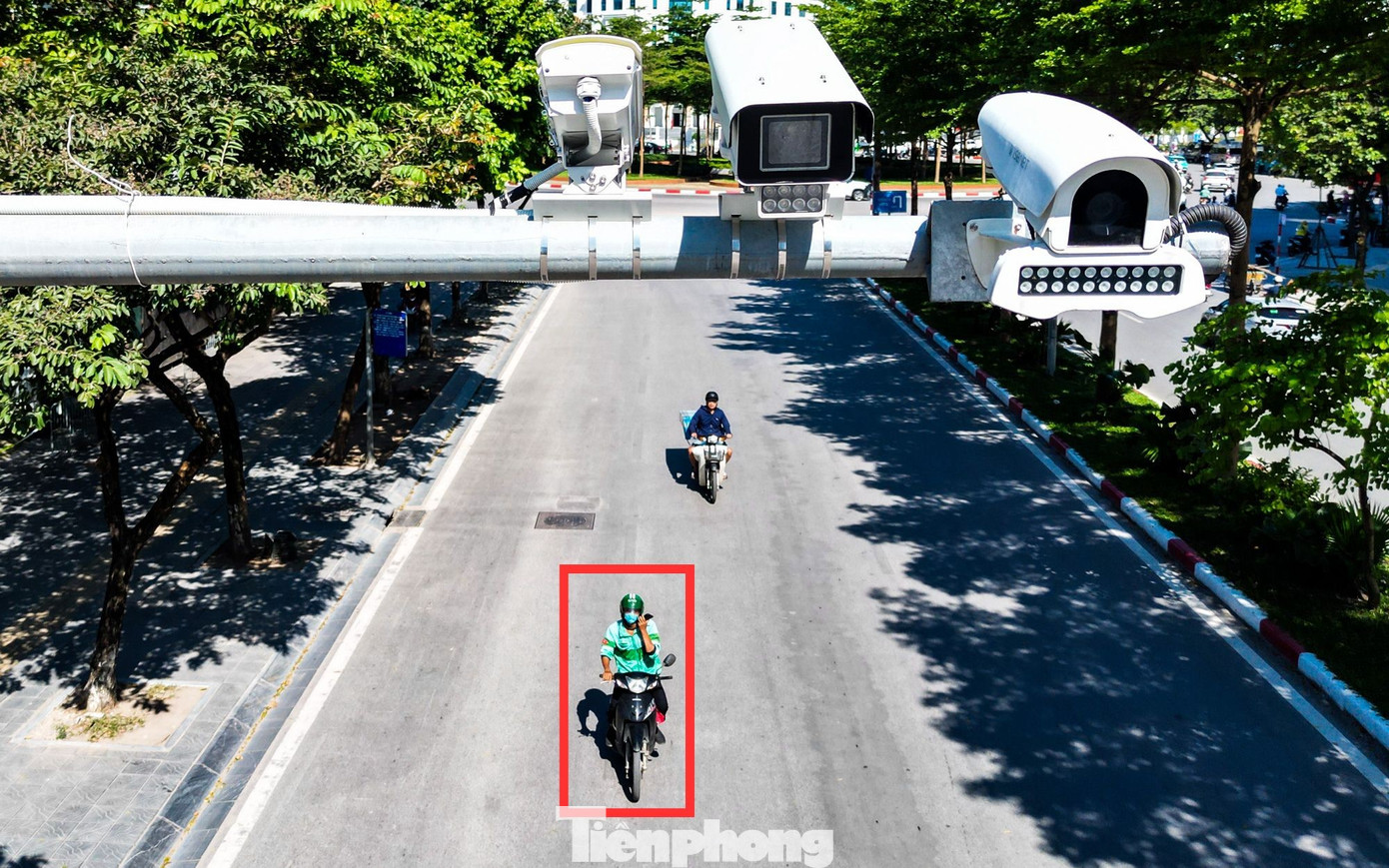 Một tài xế vừa lái xe vừa nghe điện thoại trên đường Phạm Văn Bạch