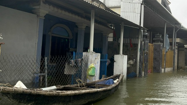 Ngoài đường nước ngập gần cả mét nên người dân đi lại bằng phương tiện ghe đò.