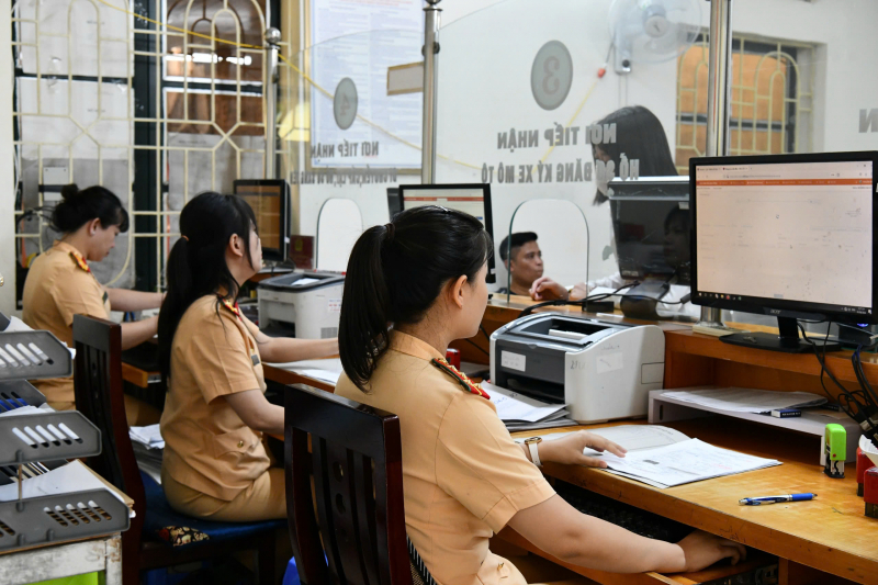 Các cán bộ CSGT hướng dẫn người dân làm thủ tục nộp phạt nguội. Ảnh: Cục CSGT