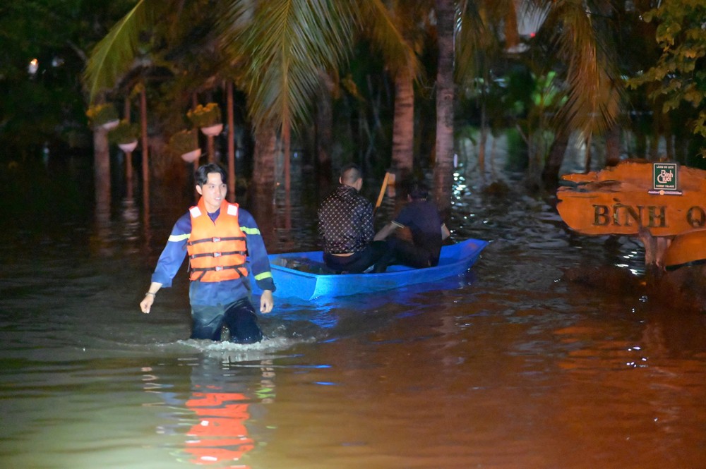 Lực lượng cứu hộ sử dụng xuồng hỗ trợ vận chuyển người già, trẻ nhỏ ra khỏi khu vực ngập sâu. Ảnh: PHẠM HẢI