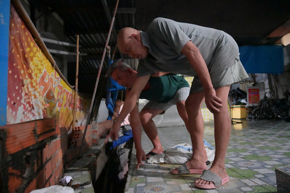 Một phần tường rào và nền nhà dân ở phường Bình Quới bị sụp sau khi nước rút, để lộ phần móng bị xói lở. Nhiều hộ dân phải di chuyển tạm thời đến nhà người thân. Ảnh: PHẠM HẢI