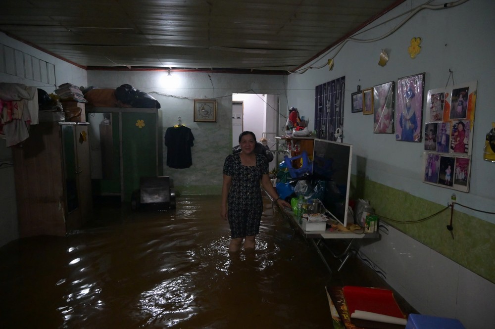 Người dân khu vực Bình Quới thức trắng đêm canh nước triều cường. Nhiều hộ phải kê cao đồ đạc, dùng bao cát chặn cửa để hạn chế nước tràn vào nhà. Ảnh: PHẠM HẢI