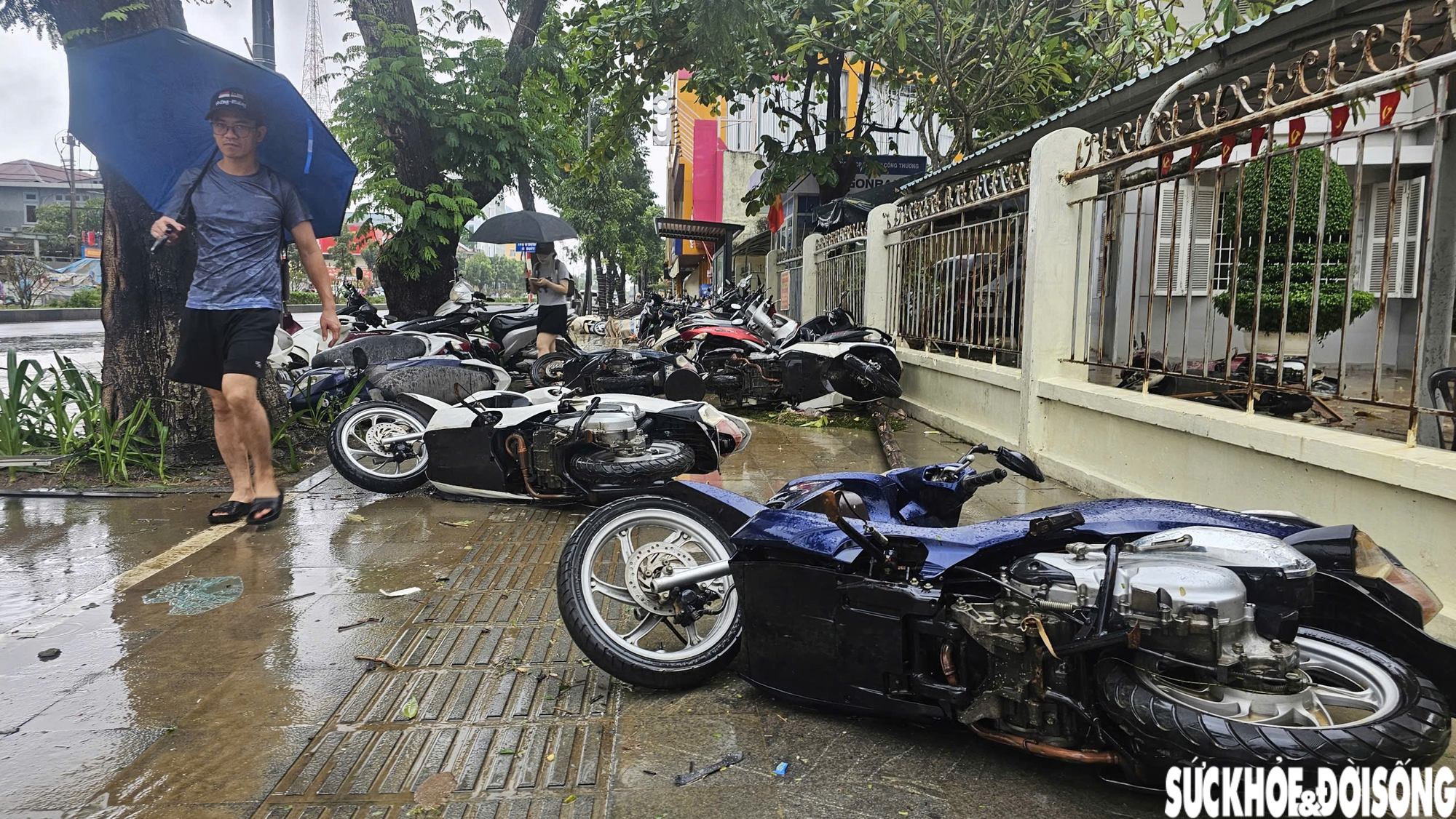 Tại các tuyến đường trung tâm như Hà Nội, Hùng Vương, hàng loạt xe máy của người dân để trên vỉa hè bị phủ đầy bùn đất, một số bị dòng nước mạnh làm đổ ngổn ngang.