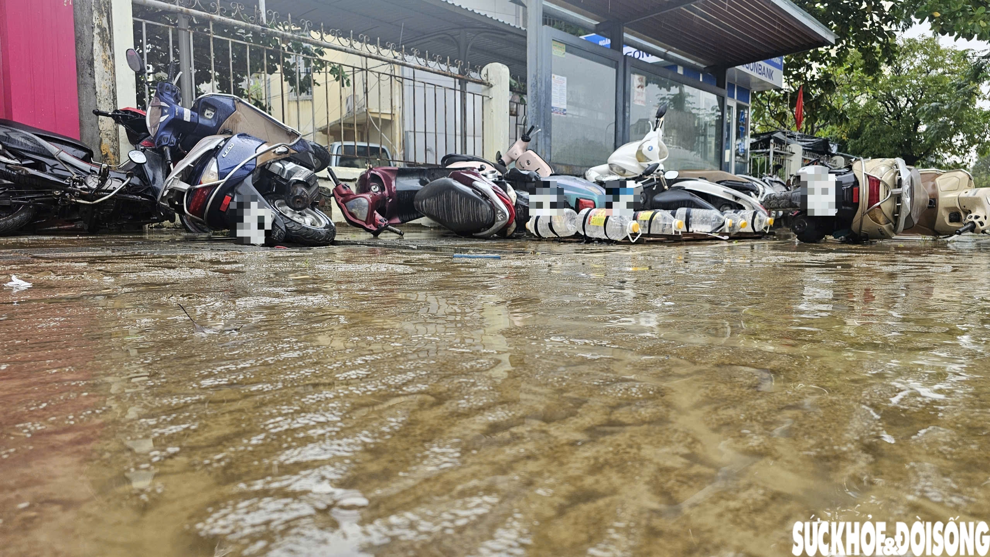 Trên mặt đường, từng lớp bùn loang lổ bám dày, nhiều phương tiện bị nước ngâm lâu nên động cơ không thể khởi động.