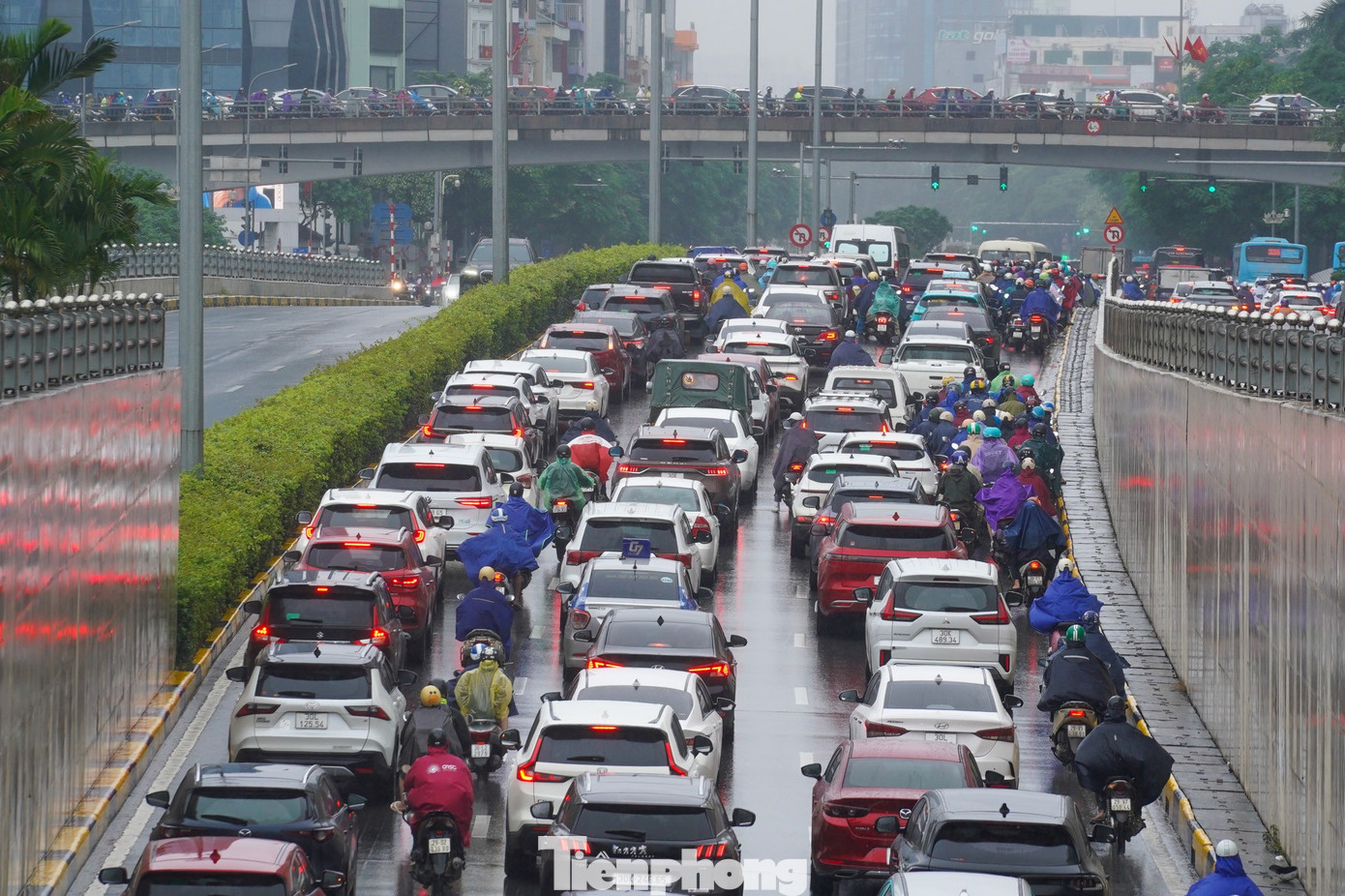 Xe cộ ken đặc trong hầm chui Trung Hòa, di chuyển khó khăn khi mặt đường trơn trượt vì mưa.