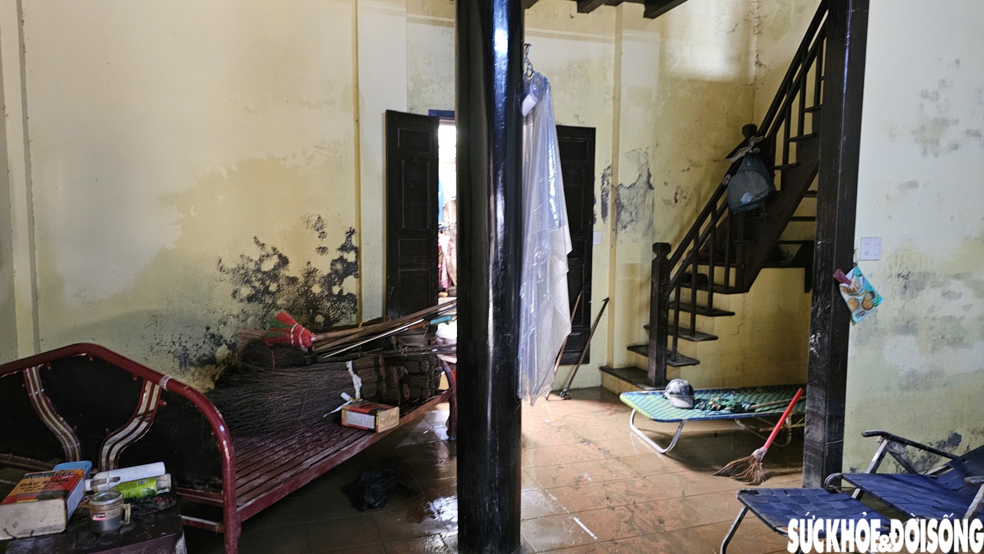 Sau khi nước rút, bà Liên bắt đầu dọn dẹp. Căn nhà của đôi vợ chồng già sau lũ vẫn còn đọng nước, nền trơn trượt, mùi ẩm mốc.
