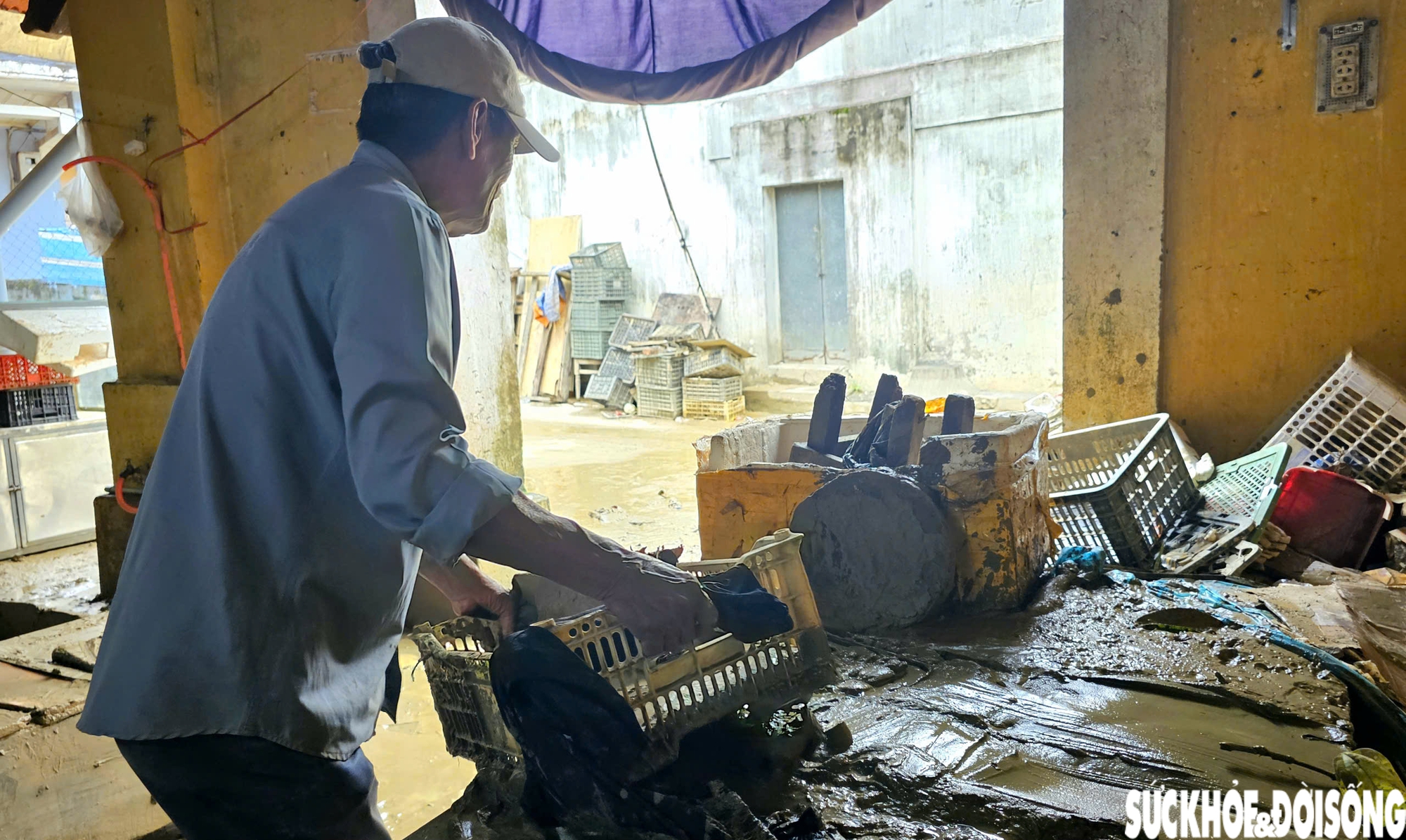 Bên trong chợ, ông Đoàn Văn Sân (thành viên tổ quản lý chợ) cùng một số hộ có sạp buôn bán đang hì hục dọn bùn đất và rác thải.