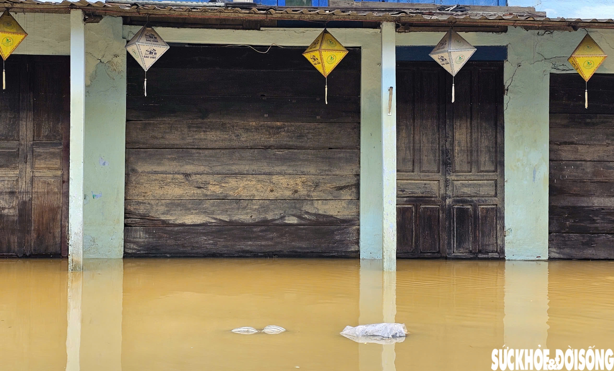 Những vết bùn bám vào dãy cửa làm bằng gỗ ở phố cổ sau lũ.