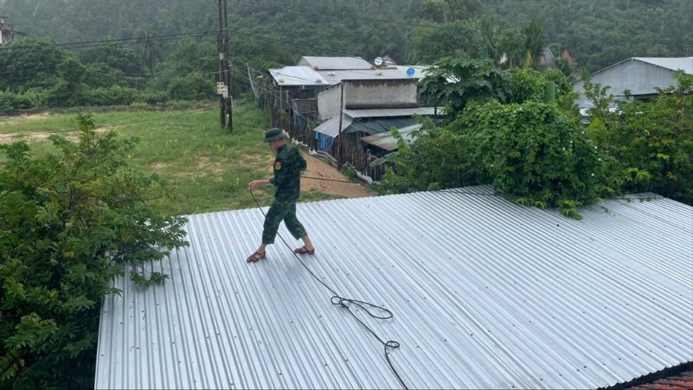 Chiến sĩ Đồn Biên phòng Xuân Đài giúp người dân gia cố mái nhà. Ảnh: X.H