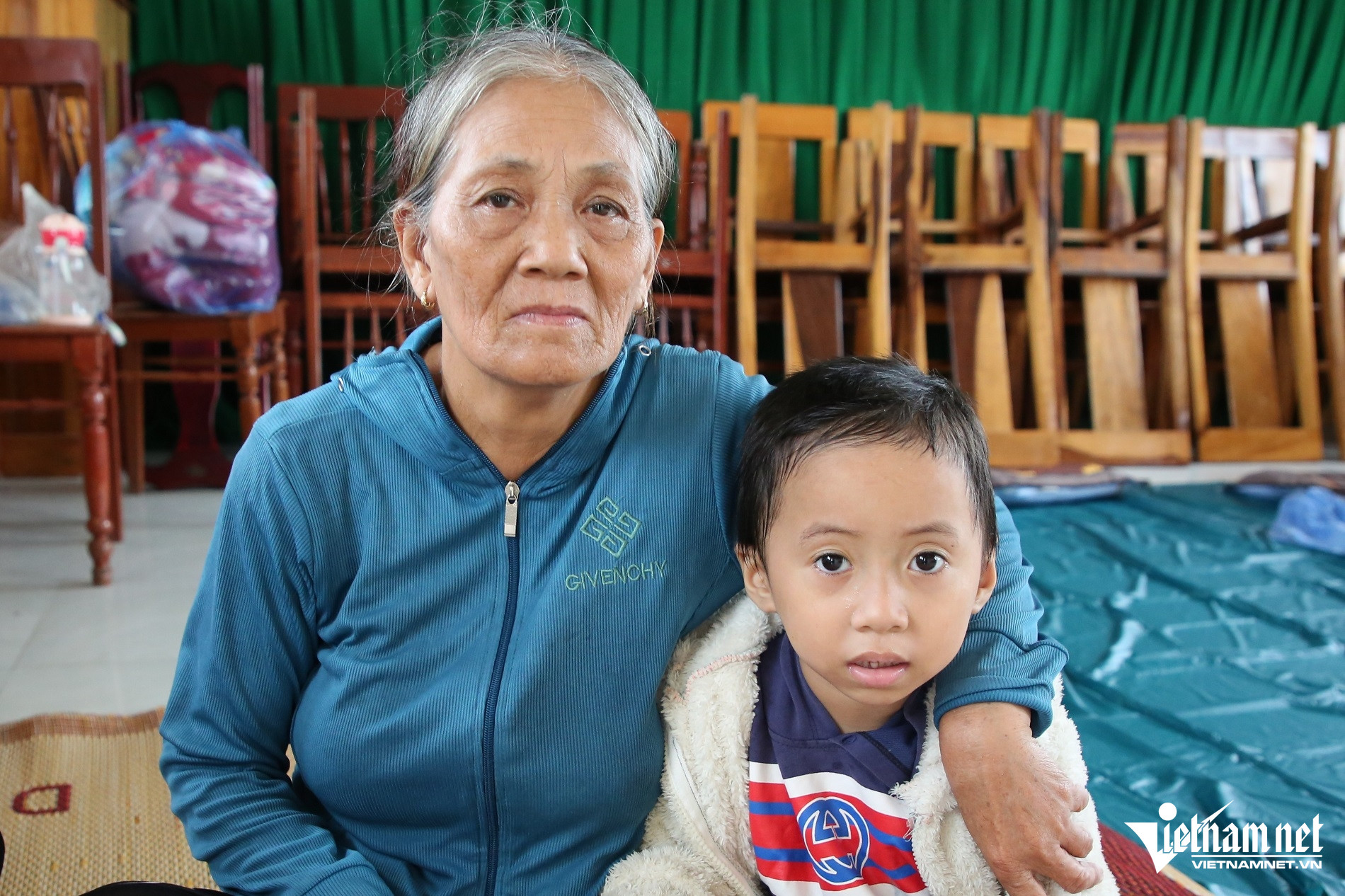 Bà Thanh cùng cháu ngoại đến trụ sở Ban chỉ huy quân sự xã An Phú để tránh bão. Ảnh: Hà Nam