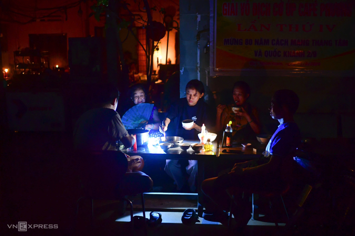 Trên vỉa hè đường Võ Lai, gần chục người trong gia đình anh Lê Văn Minh quây quần ăn cơm bên ánh nến. Nhà có nhiều người già, mất điện trời nóng không chịu nổi nên phải ra ngoài, anh Minh nói.