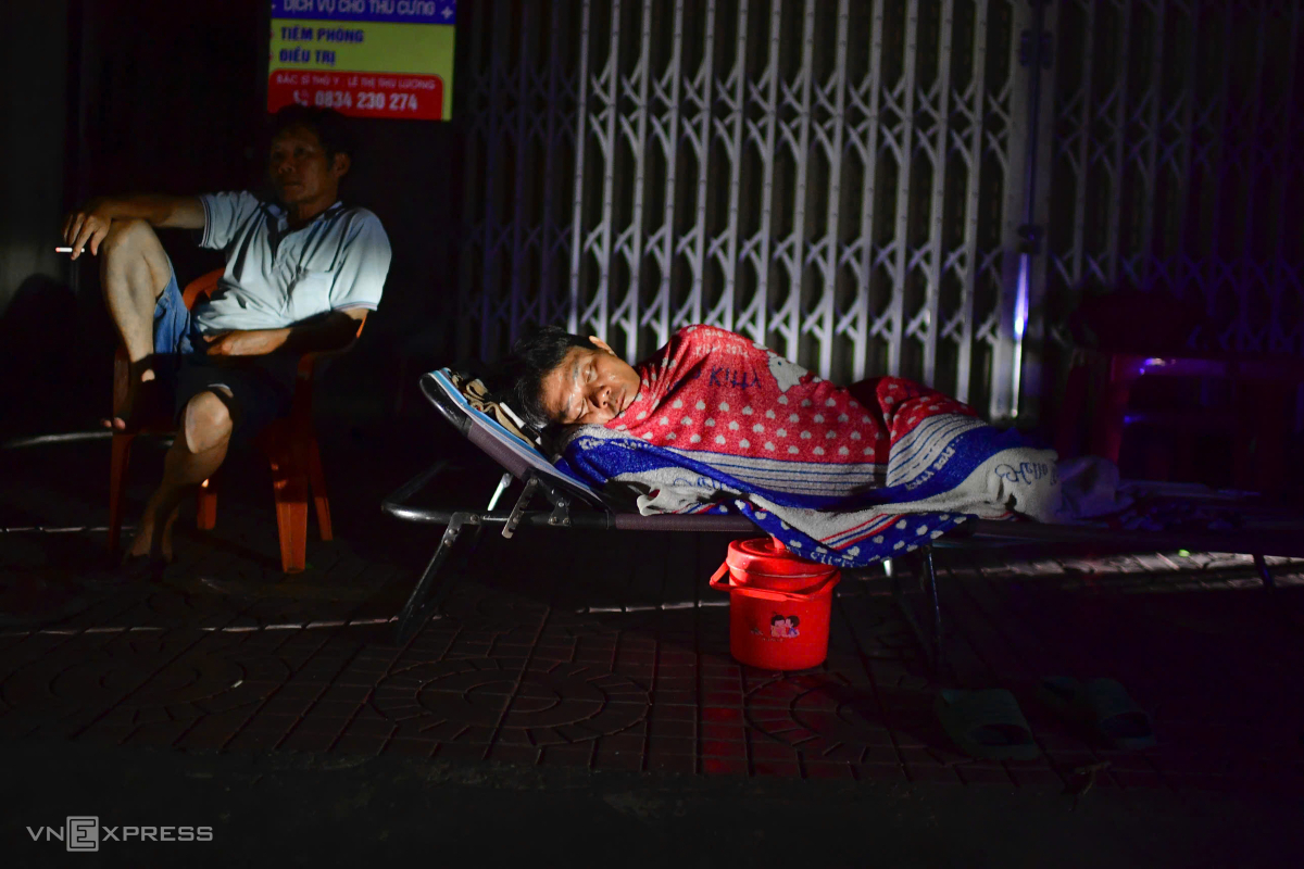 Ông Nguyễn Thành Đồng (góc trái) cùng hàng xóm ra hiên nằm nghỉ. Trong nhà nóng quá nên tôi ra ngoài cho mát, ông nói.