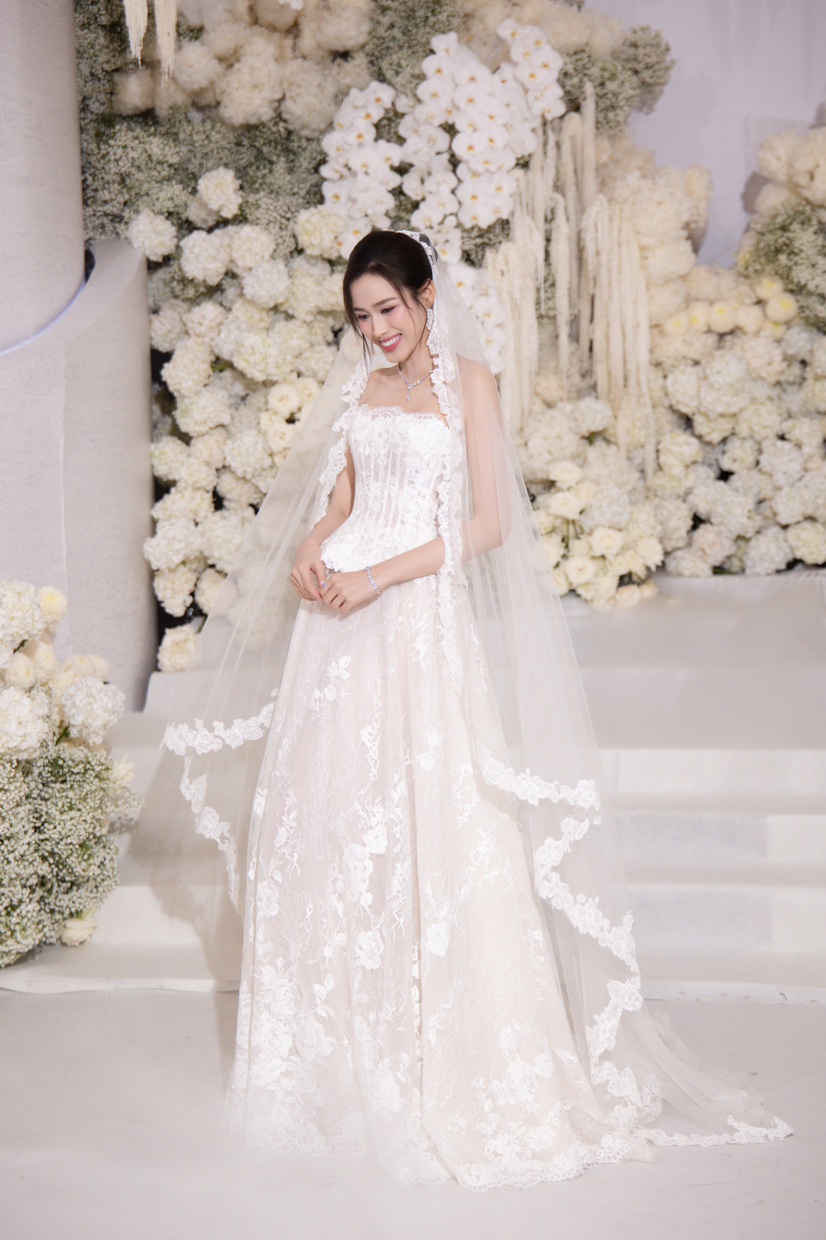 Sau khi thực hiện các nghi thức của lễ thành hôn, Đỗ Thị Hà chọn đầm dài suông lơi để thuận tiện cho việc đi bàn, chúc rượu các khách mời.