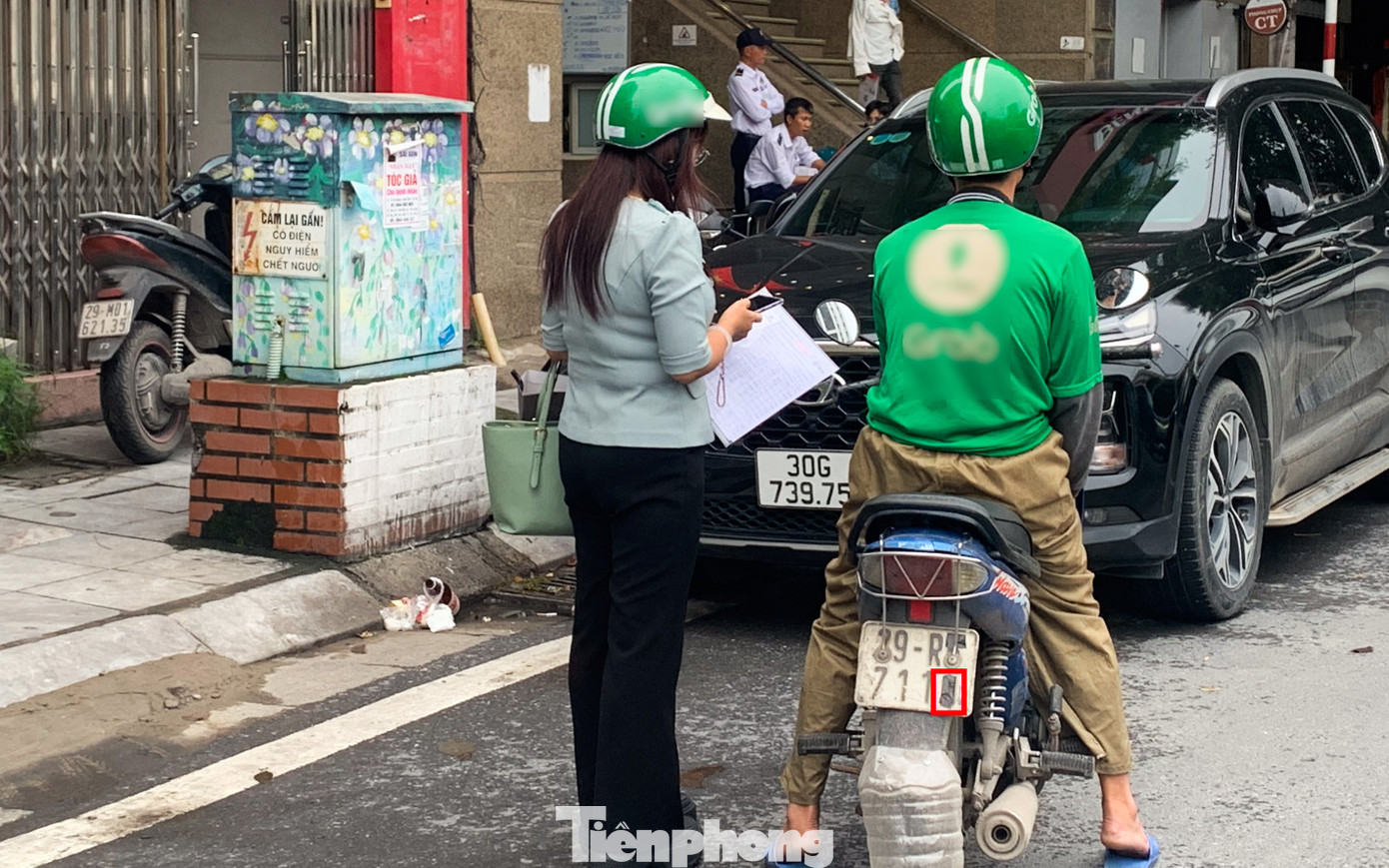 Một tài xế xe ôm công nghệ đón khách khi biển số đã bị che phần số cuối bằng miếng băng dính đen.