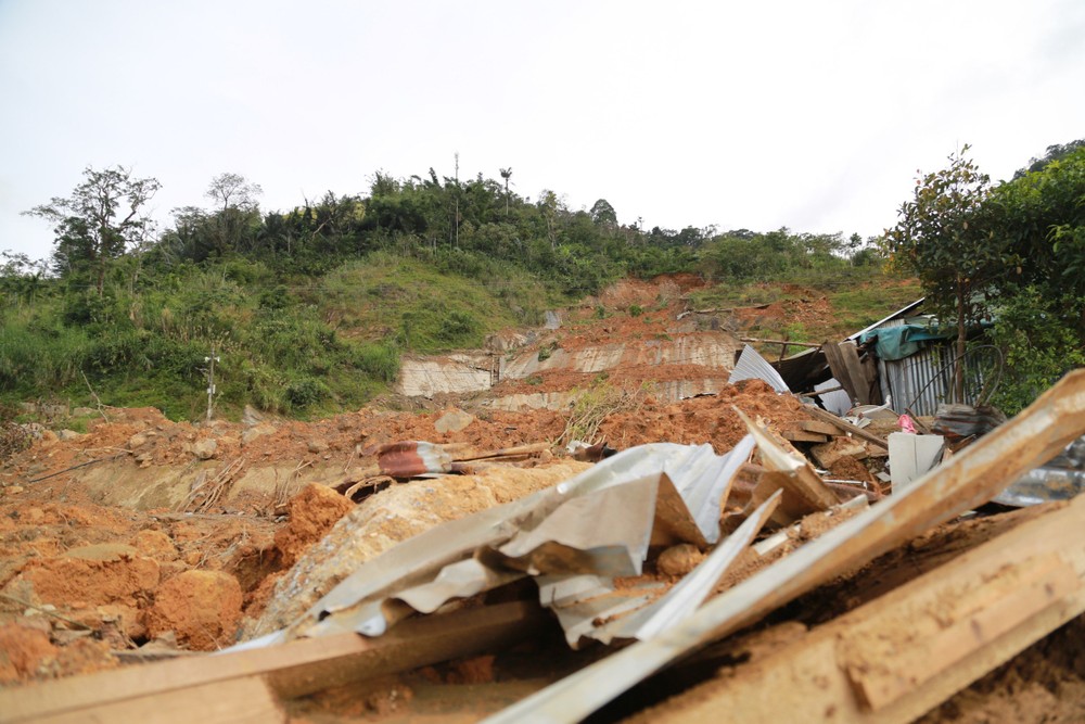 Vết sạt lở kéo dài từ trên núi xuống, băng qua đường trước khi vùi lấp nhà người dân. Ảnh: Thanh Nhật
