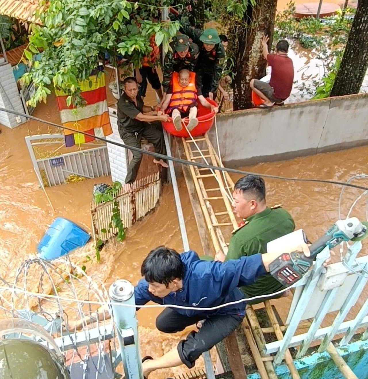 Nhiều đơn vị kịp thời hỗ trợ cụ bà ra khỏi vùng ngập sâu an toàn. Ảnh: L.K