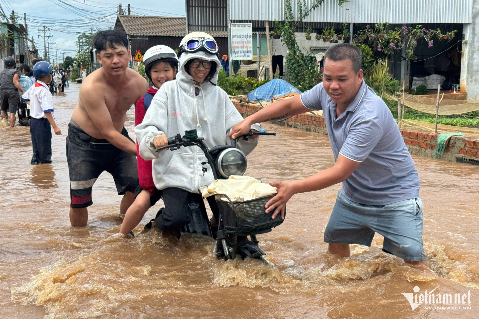 Nhiều phụ huynh phải dìu học sinh qua đoạn ngập.