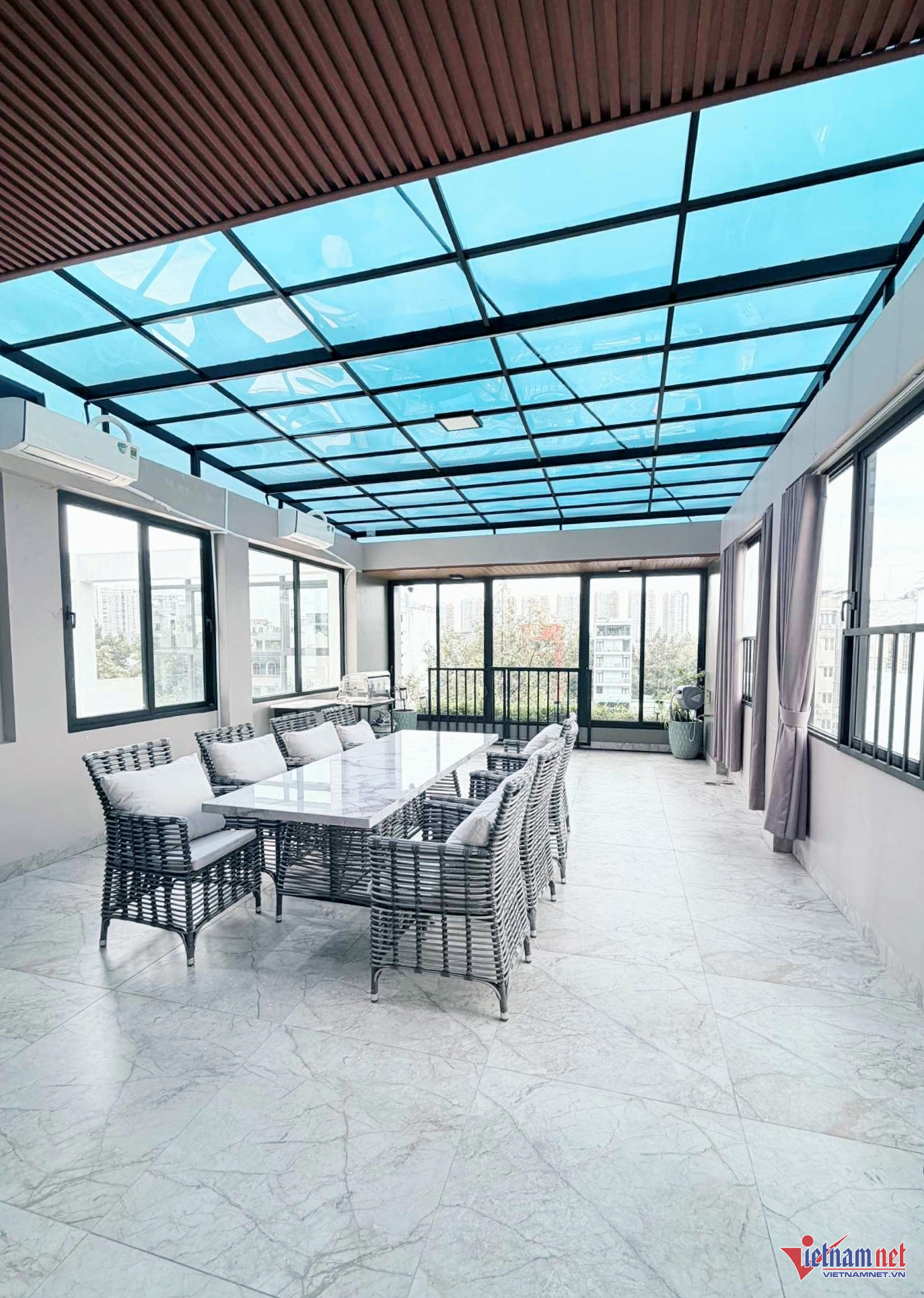 Sân thượng của ngôi nhà được xây thành không gian bán mở với nhiều cửa kính lớn, trần bằng kính xanh trong suốt, cho phép ánh sáng tự nhiên chiếu vào; có thể tổ chức tiệc gia đình hoặc đãi khách đến nhà.