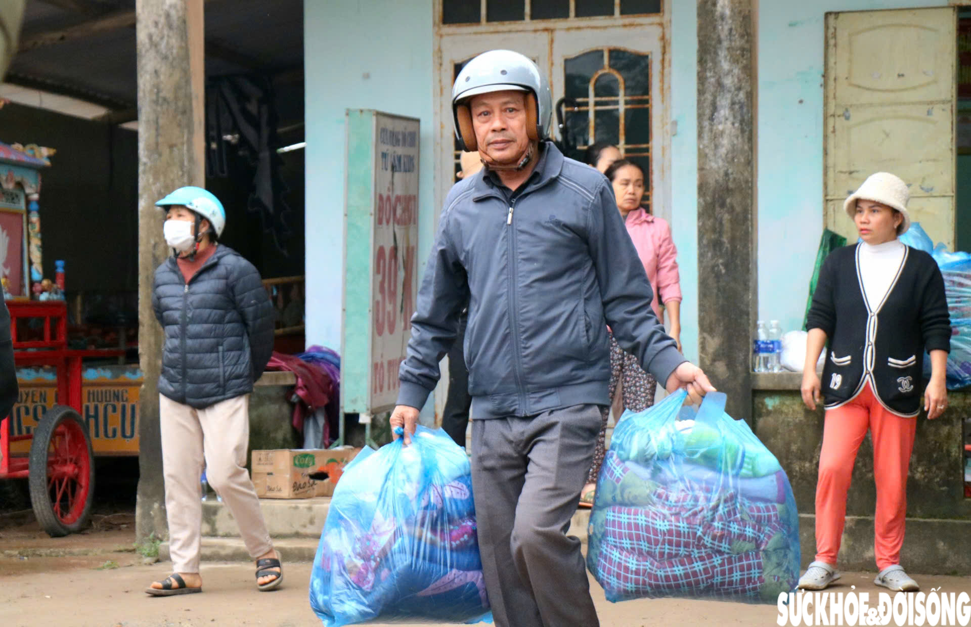 Ông Thắng đang cùng người dân bốc các gói hàng hóa lên xe để vận chuyển vào vùng lũ.