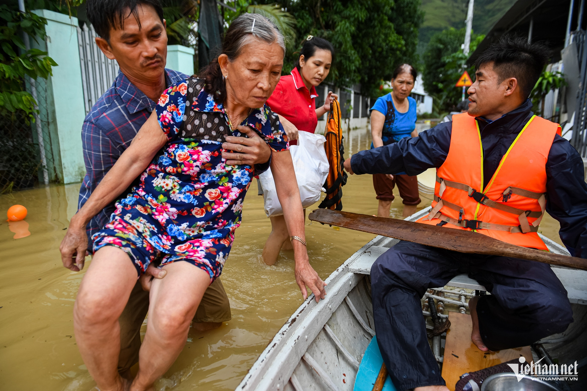 Anh Bùi Minh Nhân chèo thuyền đưa người lớn tuổi trong thôn đến nơi trú ngụ an toàn. Ảnh: Nguyễn Huế