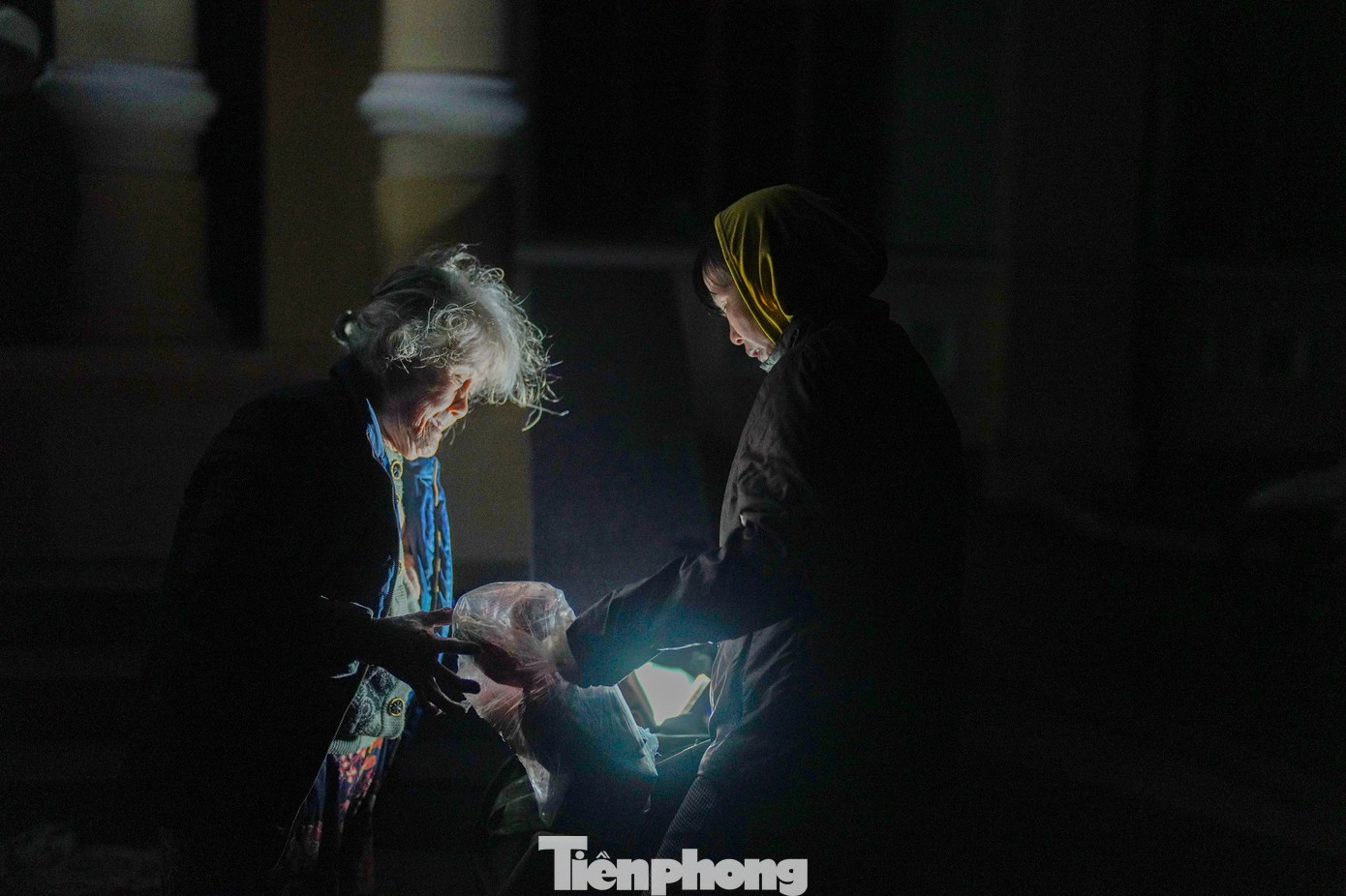 Hai mẹ con bà Lê Thị Phi san sẻ nhau từng gói mì, chiếc áo mưa vừa nhận.