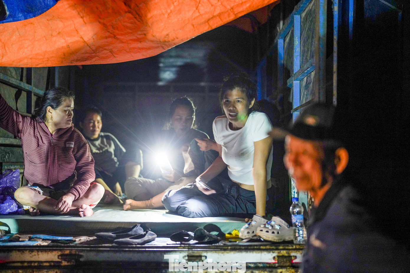 Kết thúc chuyến phát quà đầu tiên, đoàn thiện nguyện của chị Loan (áo trắng) nghỉ ngơi ngay trên thùng xe tải, chờ hàng chi viện từ Quy Nhơn (Bình Định) để tiếp tục hành trình phát quà cho người dân vùng rốn ngập vào ngày hôm sau.