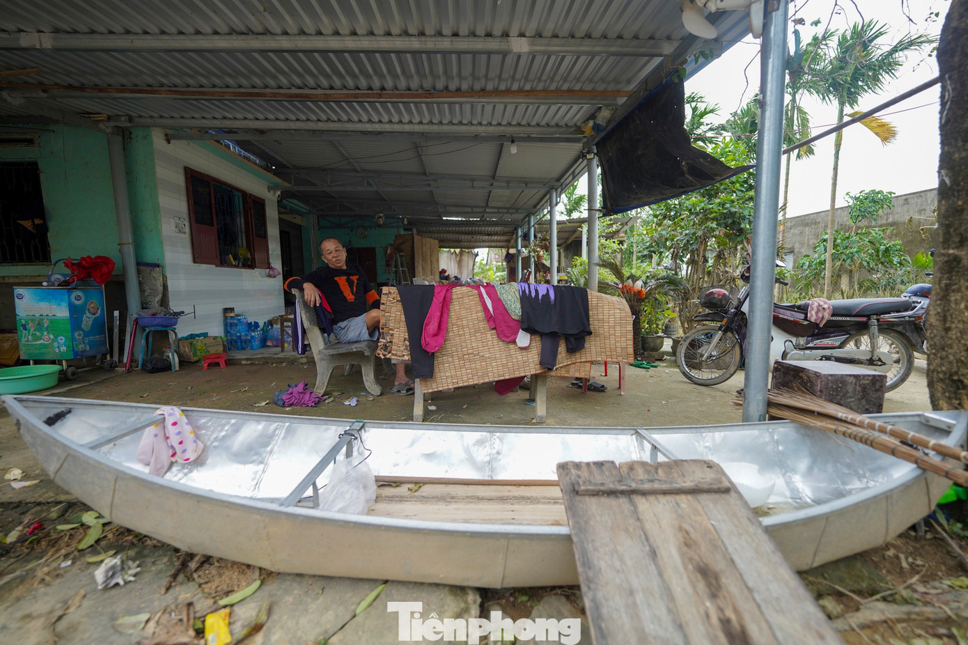 Ông ba Thành ngồi bên chiếc xuồng huyền thoại.