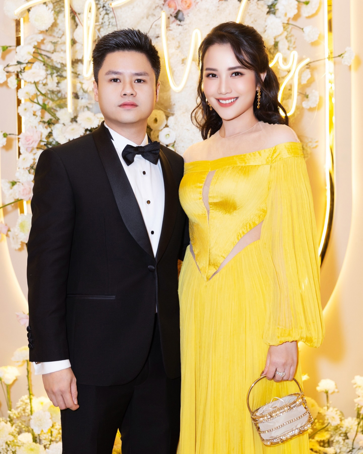 Trong khi Phan Thành bảnh bao cùng suit nơ đen, Primmy Trương e ấp trong mẫu đầm vàng với những khoảng hở chừng mực.