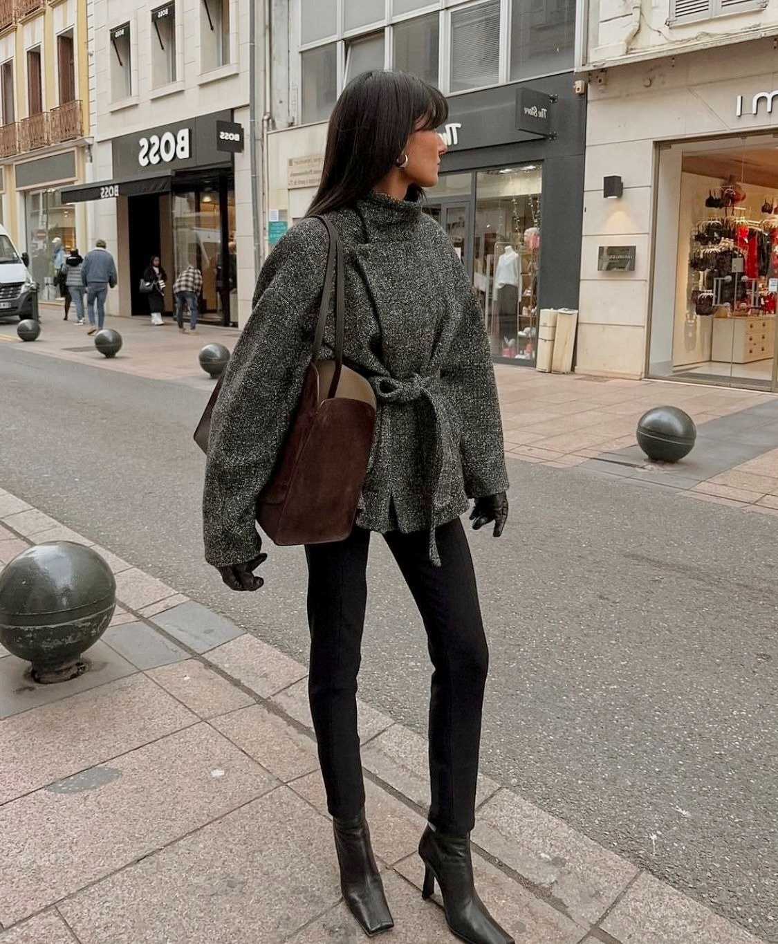 Một fashionista phối chúng với bốt và áo khoác ngắn, tạo thành trang phục công sở gọn gàng và bắt mắt.