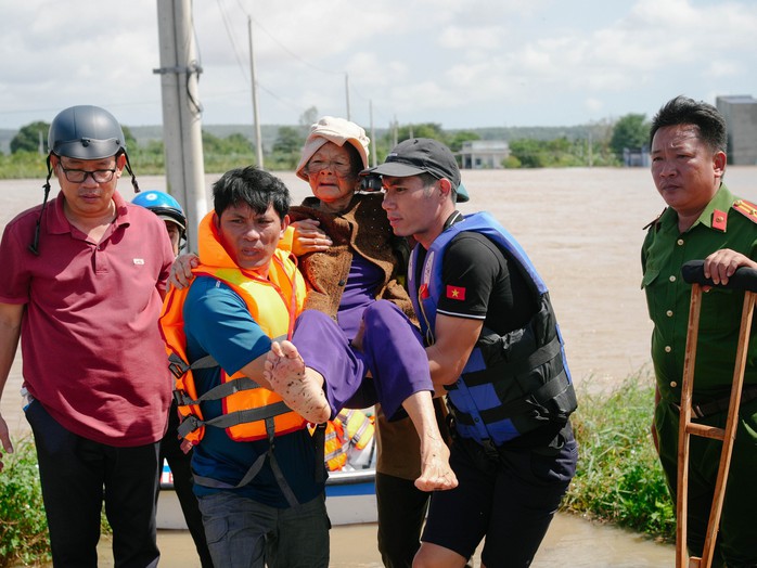 Cụ già vừa bị phẫu thuật sau gãy chân được lực lượng cứu hộ đưa ra khỏi vùng lũ, sáng 5-12 tại xã Hồng Sơn