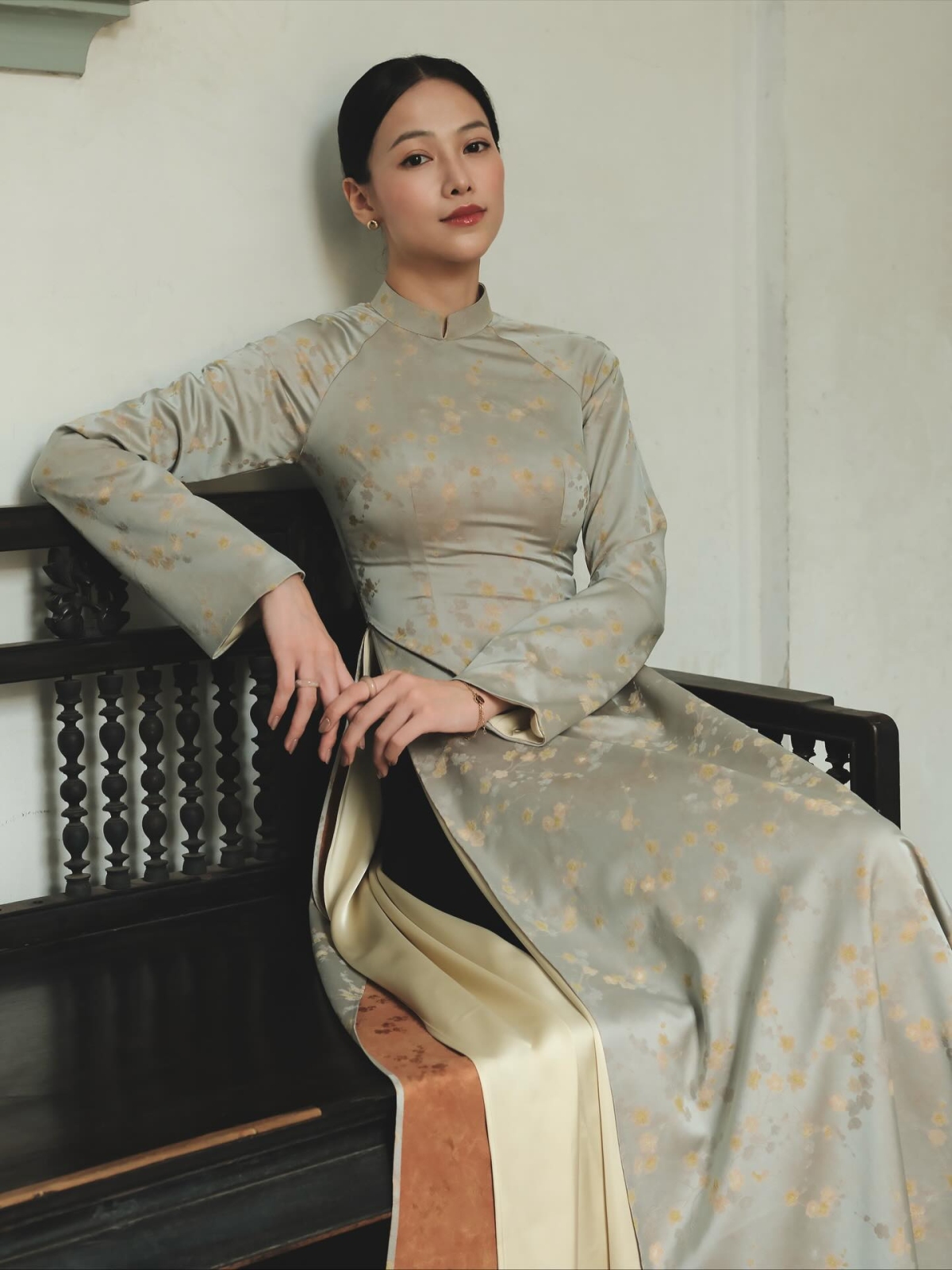 Hoa hậu Phương Khánh được khen đẹp nền nã khi mặc áo dài bốn tà với lớp ngoài họa tiết hoa nhí, bên trong là vải lụa màu vàng nhạt phối cùng quần đen.