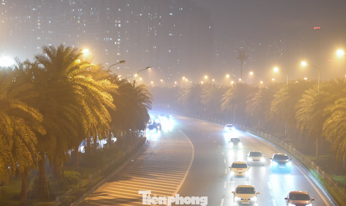 Các cột đèn đường mọc thành chuỗi nhưng cũng chỉ đủ sức rọi xuống vài mét, phần còn lại chìm vào nền không khí xám đục.