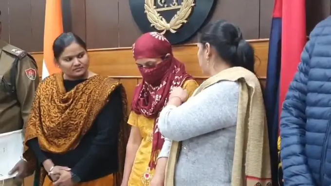 Poonam (trùm khăn đỏ) bị bắt ngày 2/12 sau khi dìm chết cháu gái. Ảnh: X