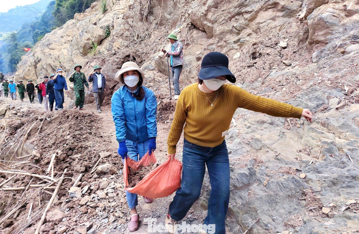 Người dân các bản tham gia vận chuyển đất đá lấp những vị trí bị xói lở tạo lối đi tạm.