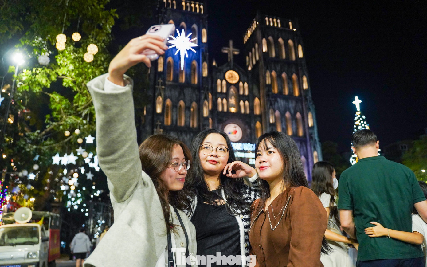 Vừa cầm điện thoại check-in cùng nhóm bạn, Ánh Dương hào hứng cho biết cả nhóm quyết định đi chơi sớm để tránh cảnh chen chúc và tận hưởng trọn vẹn không khí Giáng sinh tuyệt vời tại đây.